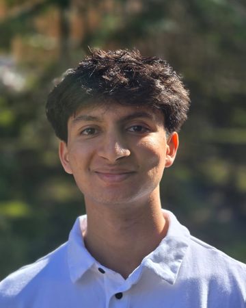 Headshot of Tejas Pandit, smiling outdoors in a white collared shirt